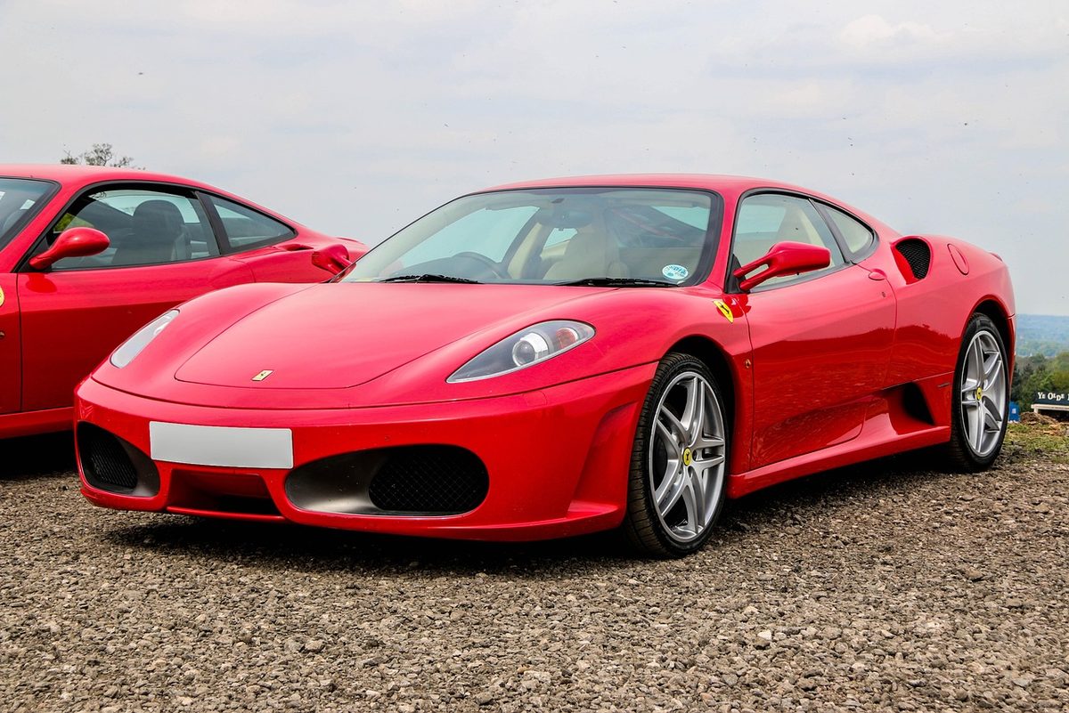 Red Ferrari F430 parked on gravel